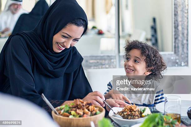 happy middle eastern mother and son having lunch - young muslim man stockfoto's en -beelden