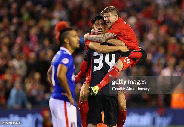 Adam Bogdan of Liverpool celebrates with Alberto Moreno and Emre Can after saving the crucial penalty from Bastien Hery of Carlisle United who looks...