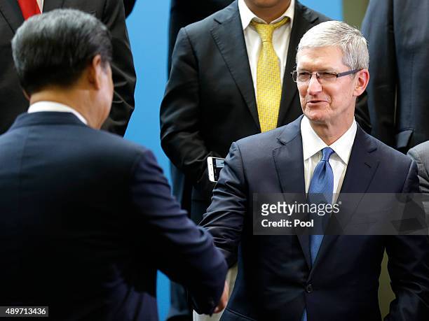 Chinese President Xi Jinping shakes hands with Apple CEO Tim Cook during a gathering of CEOs and other executives at the main campus of Microsoft...