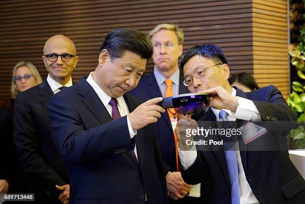 Harry Shum , Microsoft executive vice president of technology and research, demonstrates Micosoft's HoloLens device to Chinese President Xi Jinping...