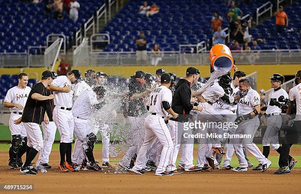 Dee Gordon of the Miami Marlins is congratulated after hitting a walkoff double in the 11th inning during a game against the Philadelphia Phillies at...