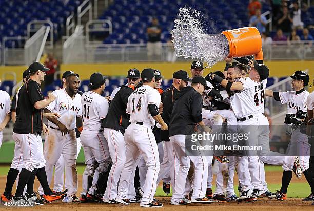 Dee Gordon of the Miami Marlins is congratulated after hitting a walkoff double in the 11th inning during a game against the Philadelphia Phillies at...