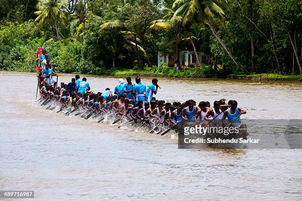 Men row a snake boat during Paipad Boat race.