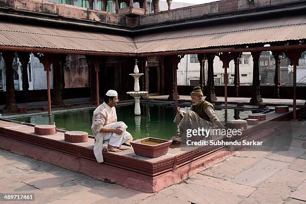 Two Muslim men engaged in conversation at Moti Masjid. The Moti Masjid was built in 1860 by Sikandar Jehan Begum. The mosque has a marble-white...