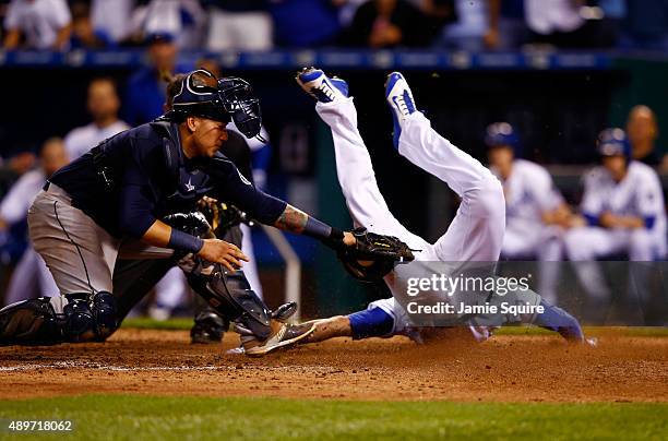 Paulo Orlando of the Kansas City Royals slides safely into home plate to score past catcher Jesus Sucre of the Seattle Mariners during the 10th...