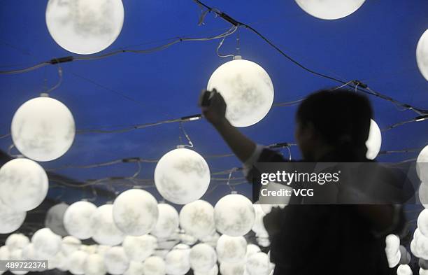 Couple of lovers pose a photo under 2,500 "moons" at a central square on September 23, 2015 in Yangzhou, Jiangsu Province of China. To Celebrate the...