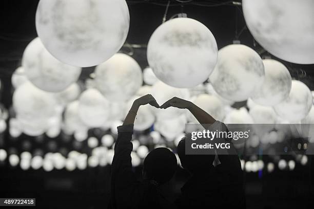 Couple of lovers pose a photo under 2,500 "moons" at a central square on September 23, 2015 in Yangzhou, Jiangsu Province of China. To Celebrate the...