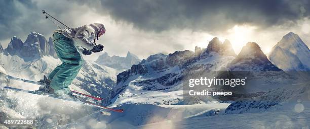 extreme skier in mid air over mountains peaks at sunset - extreem skiën stockfoto's en -beelden