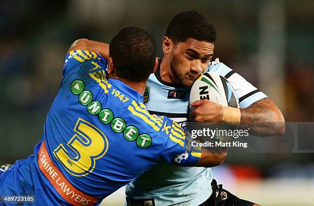 Ricky Leutele of the Sharks is tackled by Will Hopoate of the Eels during the round nine NRL match between the Parramatta Eels and the...