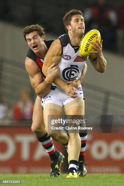 Marc Murphy of the Blues handballs whilst being tackled by Lenny Hayes of the Saints during the round eight AFL match between the St Kilda Saints and...