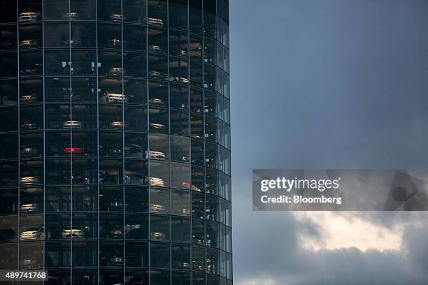 Automobiles, produced by Volkswagen AG , sit behind windows inside the auto delivery tower at the VW headquarters in Wolfsburg, Germany, on...