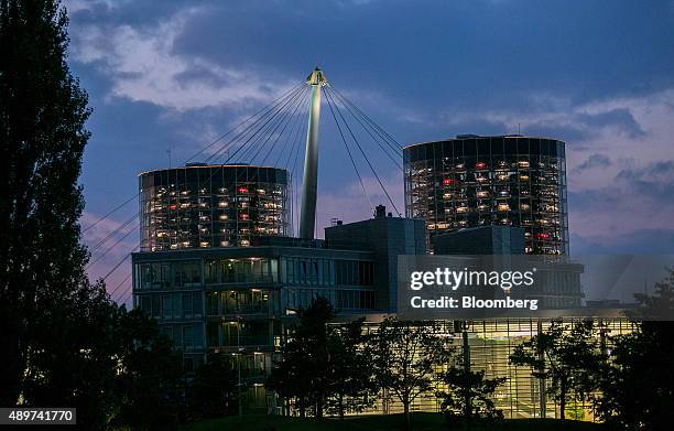 Automobiles, produced by Volkswagen AG , sit behind windows inside the auto delivery towers at night at the VW headquarters in Wolfsburg, Germany, on...