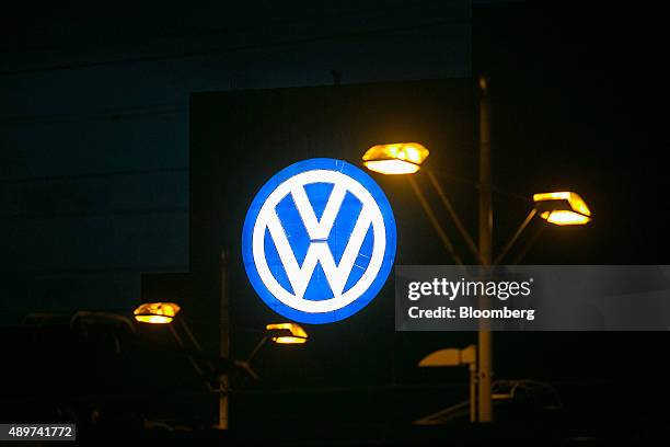 The VW logo sits illuminated at night outside the Volkswagen AG headquarters in Wolfsburg, Germany, on Wednesday, Sept. 23, 2015. Volkswagen's...