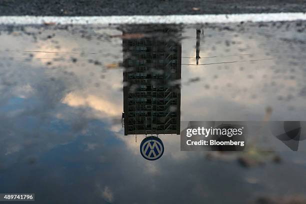 Rainwater puddle reflects a VW logo and above a building under construction at the Volkswagen AG headquarters in Wolfsburg, Germany, on Wednesday,...
