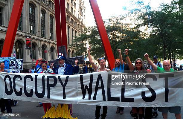 The activists bring banner and shout slogans as they gather during the 4th Anniversary of Occupy Wall Street. Occupy Wall Street is a cultural and...