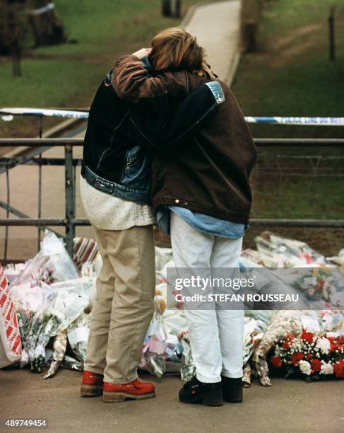 Deux jeunes gens pleurent le 14 mars 1996 devant l'entrée de l'école primaire de Dunblane où seize enfants et leur institutrice ont été tués par un...