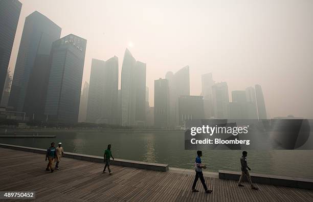 People look out towards the city skyline at Marina Bay as buildings in the central business district stand shrouded in smog in Singapore, on...