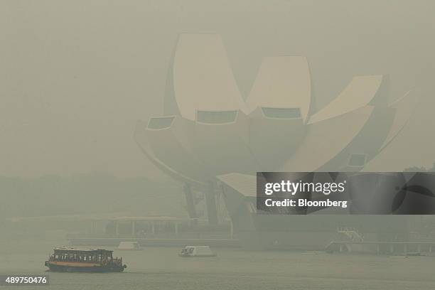 Boat passes by the Art Science Museum, which stands shrouded in smog, in the Marina Bay district in Singapore, on Thursday, Sept. 24, 2015. The haze...