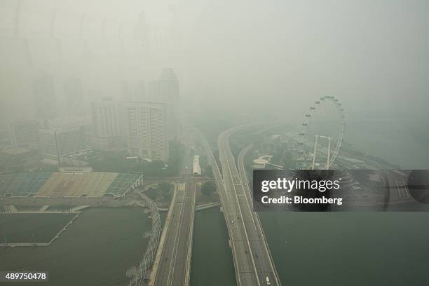 The Singapore Flyer Ferris wheel, right, stands shrouded in smog in Singapore, on Thursday, Sept. 24, 2015. The haze from Indonesian forest fires...