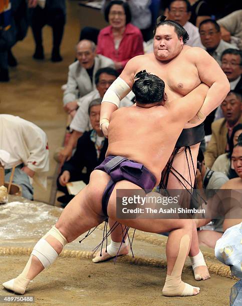 Tochiozan pushes Mongolian ozeki Terunofuji out of the ring to win during day twelve of the Grand Sumo Autumn Tournament at Ryogoku Kokugikan on...