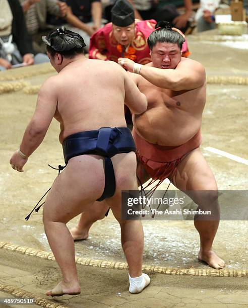 Yoshikaze pushes Ikiioi out of the ring to win during day twelve of the Grand Sumo Autumn Tournament at Ryogoku Kokugikan on September 24, 2015 in...