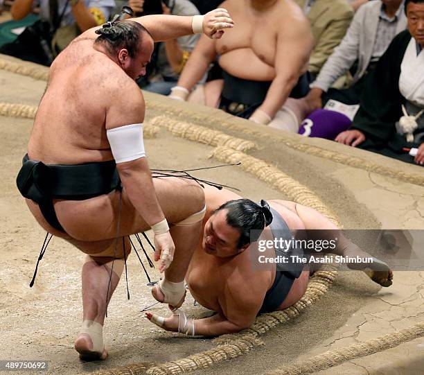 Egyptian wrestler Osunaarashi fends off as Toyonoshima falls during day twelve of the Grand Sumo Autumn Tournament at Ryogoku Kokugikan on September...