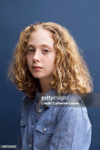 pre-teen girl on blue background - mädchen locken teenager stock-fotos und bilder