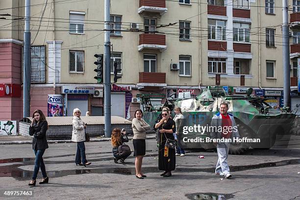 People look at at an armored personnel carrier parked in the middle of the city after it was commandeered by pro-Russia activists on May 12, 2014 in...