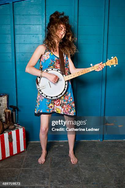 young woman rocking out with banjo and hair flying - banjo stock pictures, royalty-free photos & images