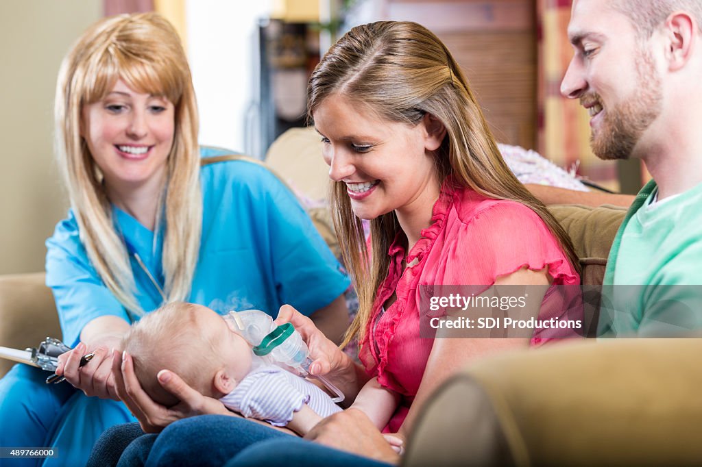 Nurse teaching parents how to give newborn baby breathing treatment