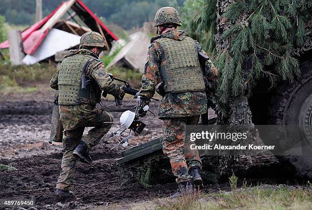 Soldiers of the German Armed Forces hold a mini helicopter Mikadoduring an excercise at the Bundeswehr training ground on September 24, 2015 in...