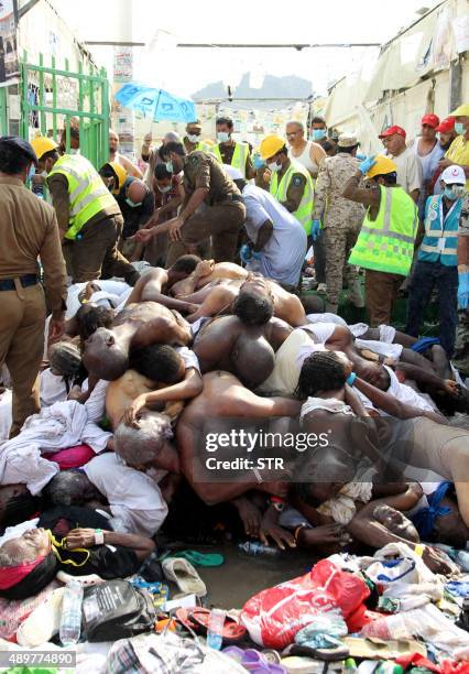 Saudi emergency personnel stand near bodies of Hajj pilgrims at the site where at least 717 were killed and hundreds wounded in a stampede in Mina,...