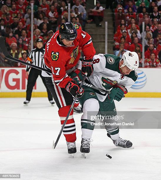 Sheldon Brookbank of the Chicago Blackhawks battles for the puck with Cody McCormick of the Minnesota Wild in Game Five of the Second Round of the...