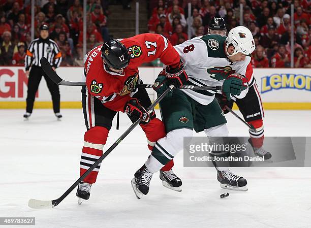 Sheldon Brookbank of the Chicago Blackhawks battles for the puck with Cody McCormick of the Minnesota Wild in Game Five of the Second Round of the...