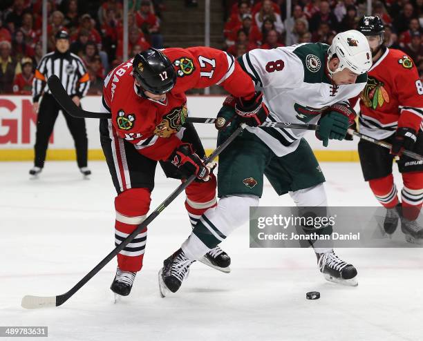 Sheldon Brookbank of the Chicago Blackhawks battles for the puck with Cody McCormick of the Minnesota Wild in Game Five of the Second Round of the...