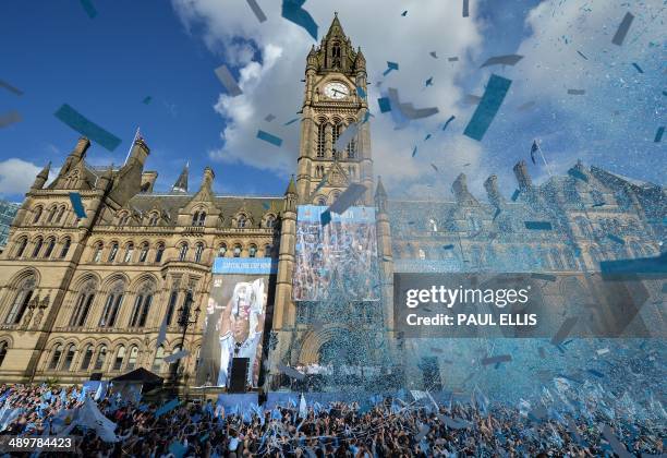 Manchester City's footballers celebrate outside Manchester Town Hall as they prepare to take part in a victory parade on an open-topped bus through...