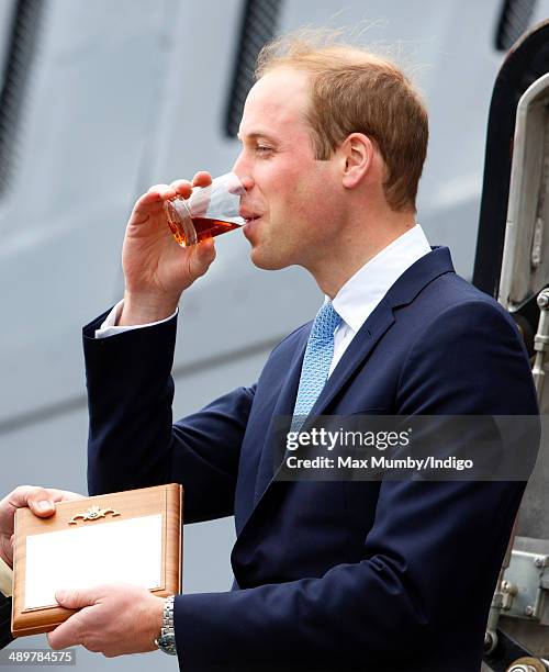 Prince William, Duke of Cambridge drinks a tot of rum after touring the newly restored submarine HMS Alliance during a visit to the Royal Navy...