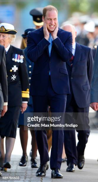 Prince William, Duke of Cambridge places his hands over his ears as he arrives for a visit to the Royal Navy Submarine Museum on May 12, 2014 in...