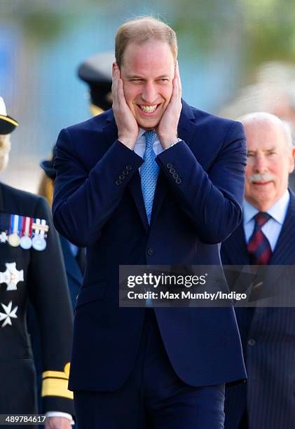 Prince William, Duke of Cambridge places his hands over his ears as he arrives for a visit to the Royal Navy Submarine Museum on May 12, 2014 in...