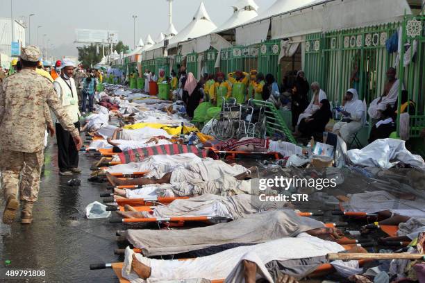 Saudi emergency personnel stand near bodies of Hajj pilgrims at the site where at least 717 were killed and hundreds wounded in a stampede in Mina,...