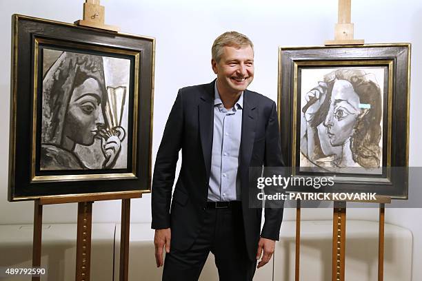 Russian businessperson and President of French football club AS Monaco Dmitry Rybolovlev poses in Paris on September 24, 2015 in front of two...