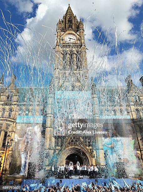 Vincent Kompany of Manchester City lifts the Barclays Premier League trophy aloft outside Manchester Town Hall at the start of the Manchester City...