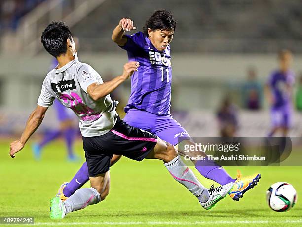 Hisato Sato of Sanfrecce Hiroshima and Hiroyuki Taniguchi of Sagan Tosu compete for the ball during the J.League match between Sanfrecce Hiroshima...