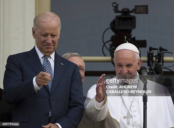 Pope Francis waves, next to US Vice President Joe Biden, on a balcony after speaking at the US Capitol building in Washington, DC on September 24,...