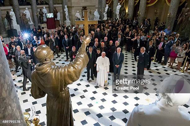 Pope Francis pauses in front of a sculpture of Spanish-born Junipero Serra, the Franciscan Friar known for starting missions in California, in...