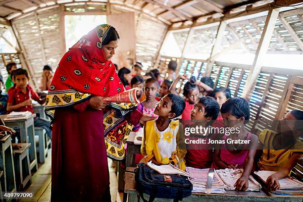 Boot school teacher explains how to do the classwork to some of the students. Shidhulai Swanirvar Sangstha has developed solar-powered floating...