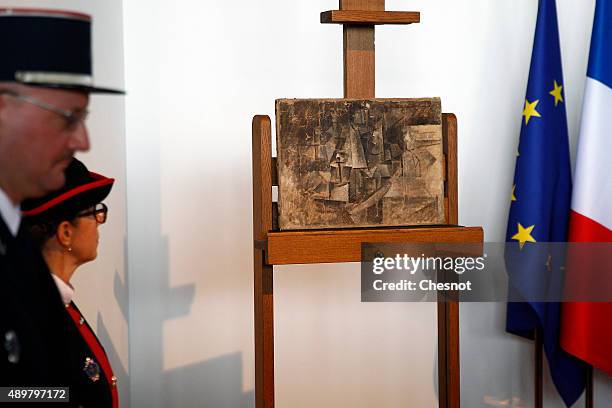 French customs officers stand guard next to an oil painting by Pablo Picasso entitled 'La coiffeuse' The hairdresser during the official presentation...