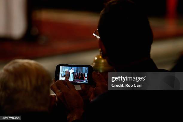 Man uses a smartphone to video tape Pope Francis speaking to those gathered at St. Patrick's Catholic Church on September 24, 2015 in Washington, DC....