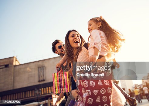 Below view of young cheerful family in shopping. Below view of young cheerful family in shopping.