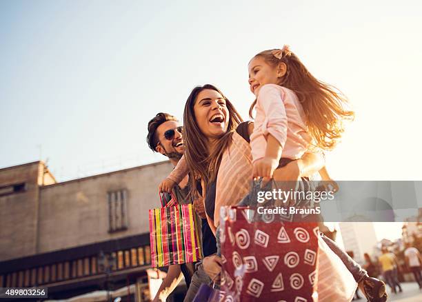 abaixo de vista da família jovem alegre em compras. - fazer compras - fotografias e filmes do acervo